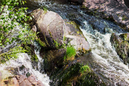 Beautiful mountain waterfall, powerful streams of water among the stonesの写真素材