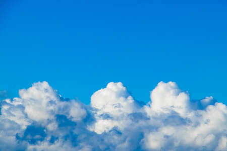 Pure fluffy white clouds on a blue sky. A symbol of purity and dreams. Background for design.の写真素材