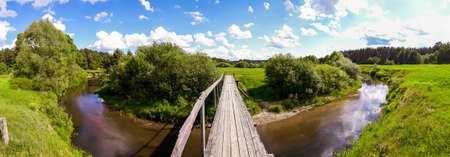Beautiful old wooden bridge over a small river