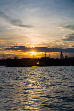 Beautiful sunset reflected in the water, city silhouetteの写真素材