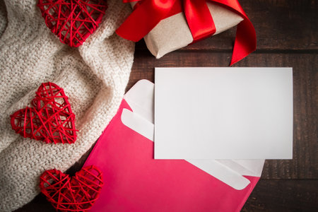 Envelope and greeting card on a wooden background. Blank postcard in a pink envelope on a wooden background. Layout for design for Valentine's Dayの写真素材