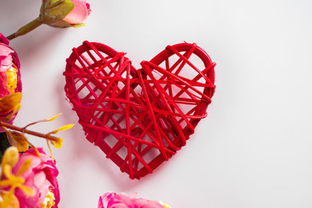 Flowers and red hearts on a white background for Valentine's Day. One red heart and pink flowers on...