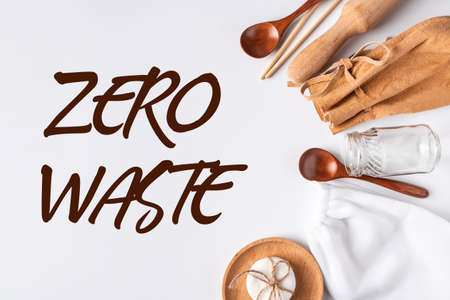 Eco-friendly recycled kitchen accessories - biodegradable bags and wooden utensils. Zero waste concept on a white background. Place for textの写真素材