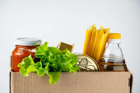 Donation box with food on a white background. Delivery of essential foodstuffs. Place for text.の写真素材