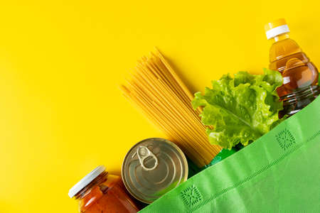 Delivery of necessary food during quarantine. Donation foodstuffs on a yellow background, place for your text.の写真素材