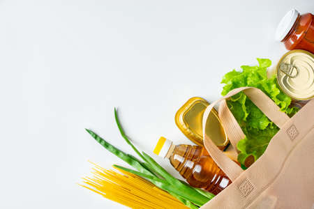 A bag of donated food. The concept of the delivery of necessary foodstuffs on a white background. Place for text.の写真素材
