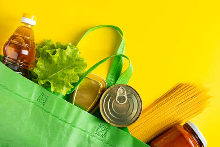 Delivery of necessary food during quarantine. Donation foodstuffs on a yellow background, place for your text.の写真素材