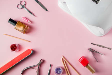 A set of tools for manicure and nail care on a pink background. Workplace in a beauty salon. Place...