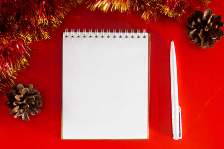 Blank notebook and pen on the background of Christmas decorations. Layout for plans for the new year.の写真素材