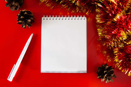 Blank notebook and pen on the background of Christmas decorations. Layout for plans for the new...