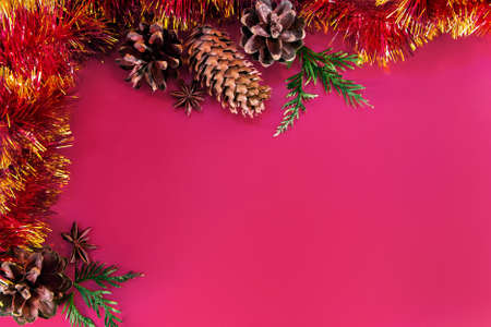Christmas decor - cones, Christmas balls and branches on a pink background. Aroma candle for a pleasant holiday. Place for your text.の写真素材