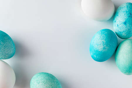 Frame of blue easter eggs on a light background. Minimalistic frame of easter eggs in blue on a white background. Place for your text.の写真素材