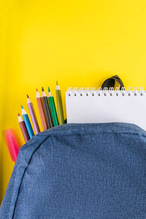 Flat lay student backpack and office supplies on a yellow background. Back to school concept. Place for text.の写真素材