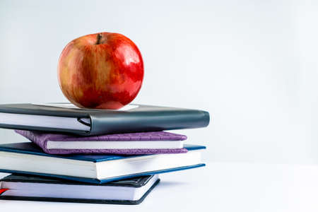 Books and apple on a white background. Back to school concept. Place for text.の写真素材