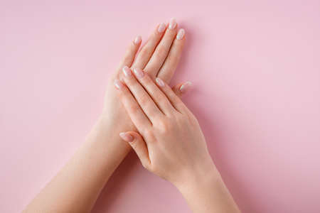 Beautiful female hands on a pink background. Spa and body care concept. Image for advertising.
