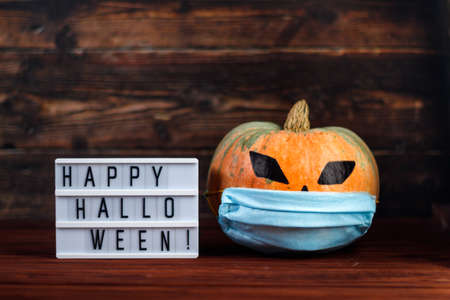 Halloween 2020. Pumpkin with a protective medical face mask. Holiday and coronavirus concept.の写真素材