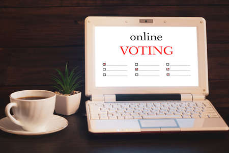 Online voting and elections concept. Laptop and a cup of coffee.の写真素材