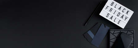 Black Friday sale. Smartphone and accessories on a dark background. Monochromatic flatlay, online shopping concept.の写真素材