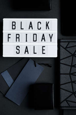 Black Friday online sale concept. Monochromatic flatlay on a dark background. Smartphone and...