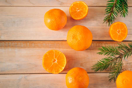 Fir branches and tangerines on wooden background. Christmas and new year concept. Place for text.の写真素材