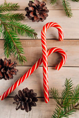 Fir branches and candies on wooden background. Christmas and new year concept. Place for text.の写真素材