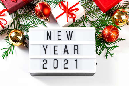 Festive composition for New Year 2021. Gift boxes with red ribbon and golden Christmas balls on a white background.の写真素材