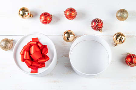 Festive composition. Gift boxes with red ribbon and Christmas balls on a white background.