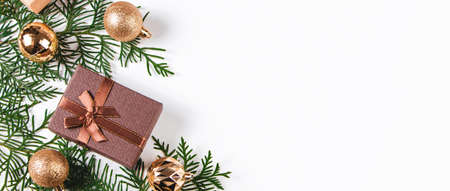 Stylish golden Christmas balls and gifts on white background. New Year's composition, place for...