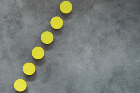 Yellow circles on gray background. Minimalistic geometric concept for design. Trending color of 2021.の写真素材