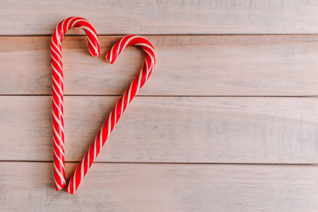 Two Christmas candy canes in shape of heart. Valentine's day concept. Place for text.の写真素材