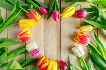 Heart of tulip flowers on wooden background. Valentine's day, place for text.の写真素材