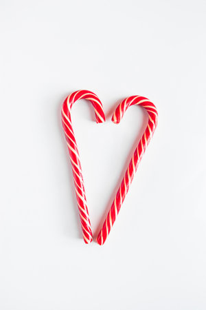 Two Christmas candy canes in shape of heart. Valentine's day concept. Place for text.