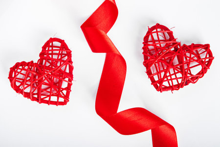 Valentine's day concept. Red silk ribbon and heart on white background.