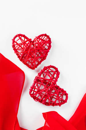 Two hearts and red silk ribbon. Symbol of lovers for Valentine's day, place for your text, vertical photoの写真素材