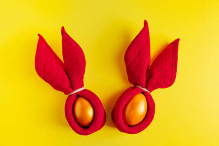 Gold glittering Easter eggs on  yellow background. Happy spring holiday.