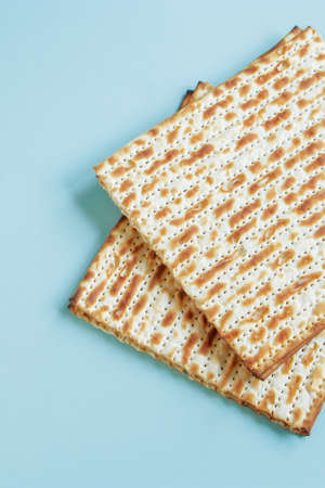 Matzo on blue background. Happy Passover concept. Traditional Jewish food for Pesach. Vertical photo.の写真素材