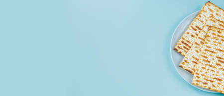 Happy Passover banner. Matzo on blue background. Traditional Jewish food for Pesach. Copy space.の写真素材