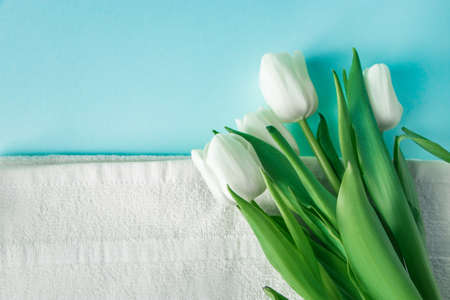 Organic cosmetics for spa treatments and tulips on blue background. Skin care and hygiene concept. Place for text.の写真素材