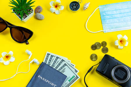 Passport, medical mask and sunglasses on a yellow background. Safe travel concept during the coronavirus pandemic. Flatlay, copy space.の写真素材