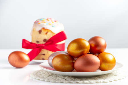 Easter cake with sweet icing and golden eggs on white plate. Happy spring holiday.