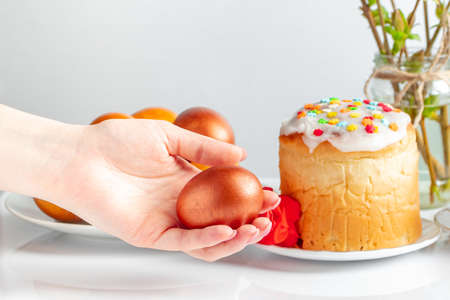 Hand holds shiny Easter egg. Symbol of spring and happy holiday.