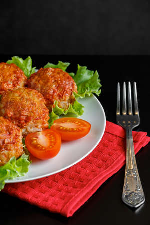 Appetizing meat balls in tomato sauce on a dark background. High protein healthy dish.