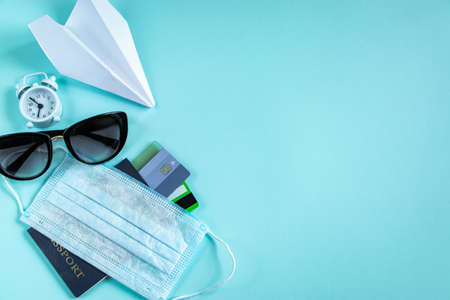 Buying plane tickets during the coronavirus pandemic. Passport, credit cards and medical mask....
