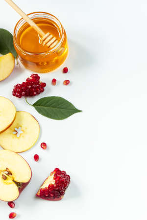 Traditional Jewish holiday New Year. Happy Rosh Hashanah. Apples, pomegranates and honey on a white background. Vertical photo.の写真素材