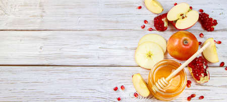 Rosh Hashanakh Jewish religious holiday. Banner format. Apples, pomegranates and honey on a white wooden background. Traditional symbolsの写真素材