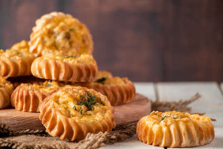 Fresh muffins with vegetables and cheese on a wooden board. Delicious homemade cakes for healthy...