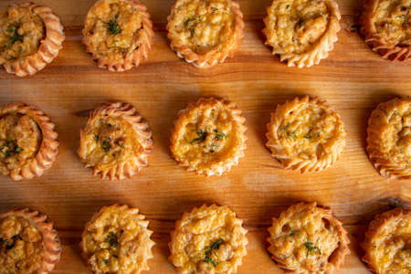 Muffins with vegetables and cheese on a wooden board. Fresh homemade cakes for a healthy diet. Preparation of seasonal fall food.の写真素材