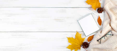 Hello autumn. Yellow leaves, notepad and glasses. Stylish workspace. Flat lay composition on a white...