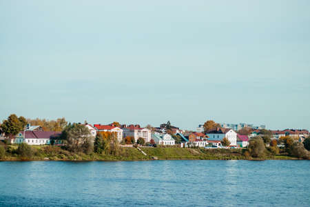 City view on a sunny day. Houses stand on the banks of the river. Countryside.の写真素材