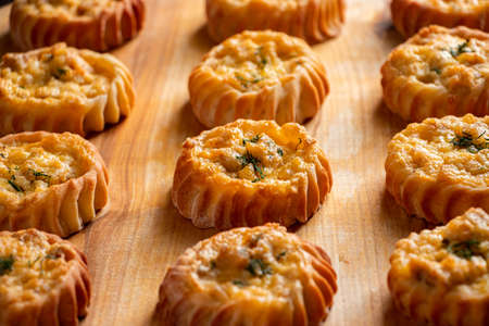 Muffins with vegetables and cheese on a wooden board. Fresh homemade cakes for a healthy diet. Preparation of seasonal fall food.の写真素材